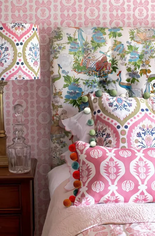 Pink patterned curtain with multicolor pom pom trim in a playful bedroom setting