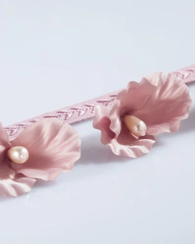 Pink lace curtain trim with pearl-centered floral accents for romantic décor