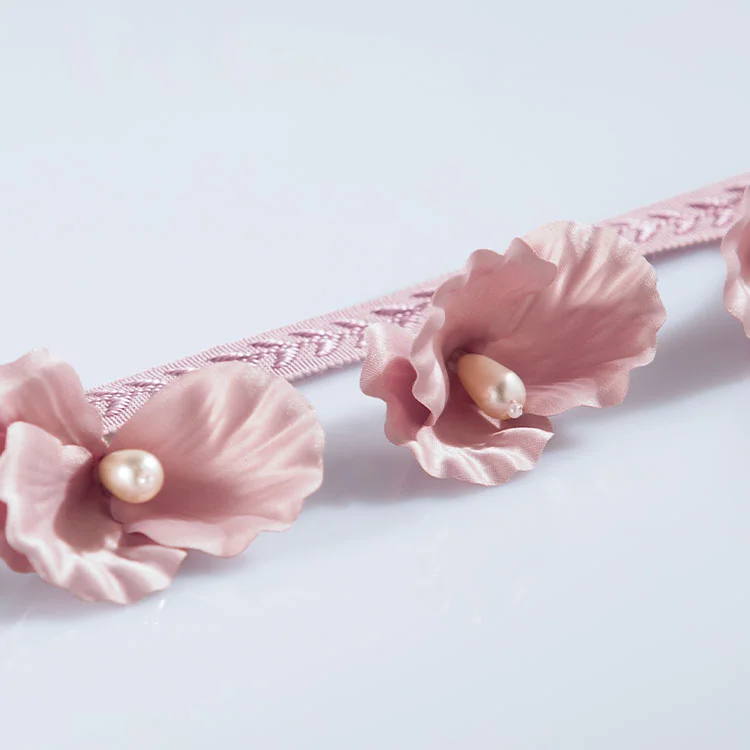 Pink lace curtain trim with pearl-centered floral accents for romantic décor