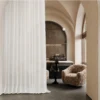 Lightflow lace curtain softly draping in an arched hallway with warm ambient light