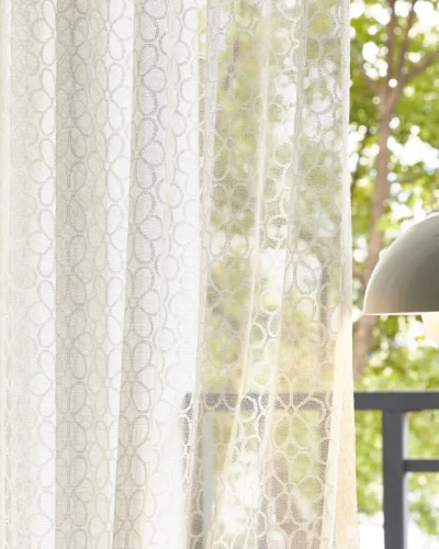 Lightflow lace curtain with elegant geometric patterns by a sunny window