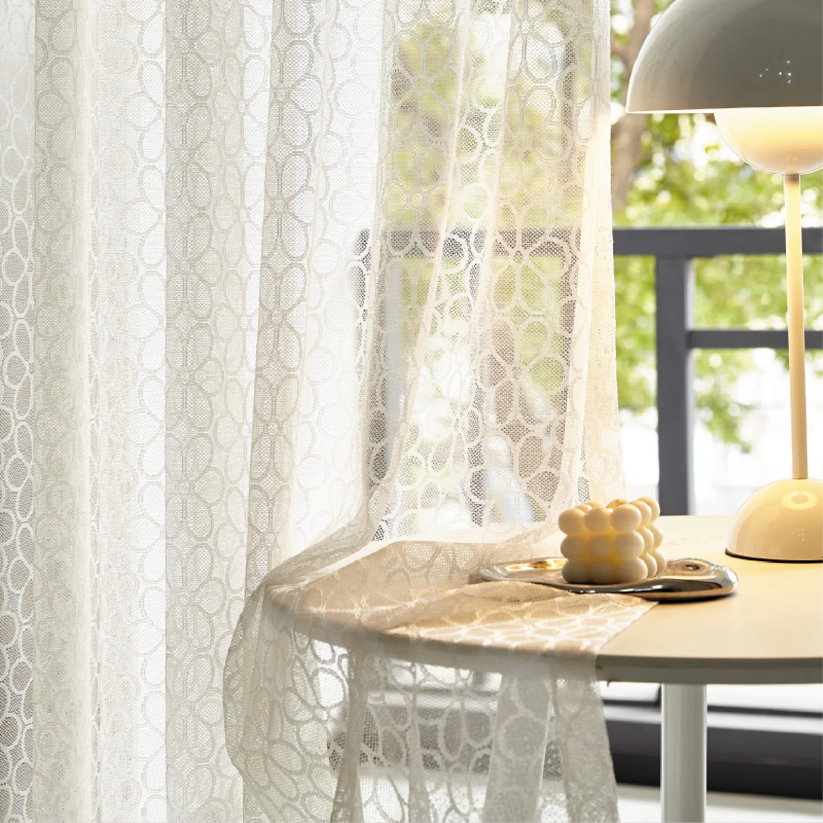 Lightflow lace curtain draped beside a sunny table setup in a serene room