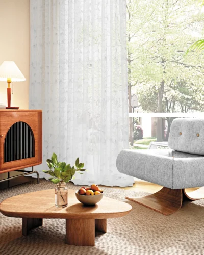 Leaf texture sheer curtain in a modern living room, softly filtering sunlight beside a window with natural scenery