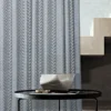 Zigzag sheer curtain hanging beside a staircase and round table