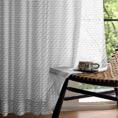 White jacquard sheer curtain with geometric texture, softly filtering light in a modern living space