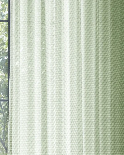 Green geometric sheer curtain filtering natural light by the window