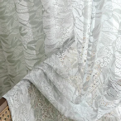 Close-up of dual-tone jacquard sheer curtain with delicate leaf embroidery and flowing drape.