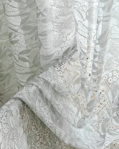 Close-up of dual-tone jacquard sheer curtain with delicate leaf embroidery and flowing drape.