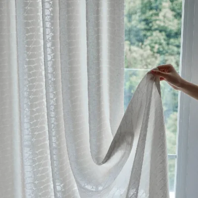 Close-up of hand lifting Echo Leaf Curtain to show double jacquard texture and soft light filtering