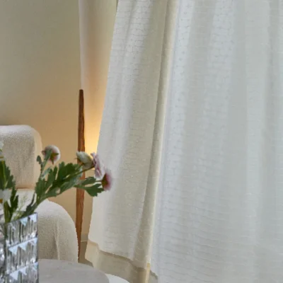 Echo Leaf curtain in soft jacquard voile draping beside a flower vase