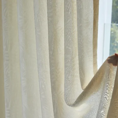 Close-up of botanical jacquard sheer curtain softly draping with filtered sunlight