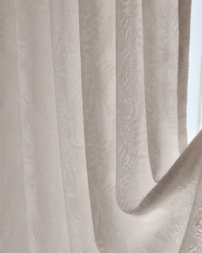 Close-up view of botanical jacquard texture on sheer curtain in natural light