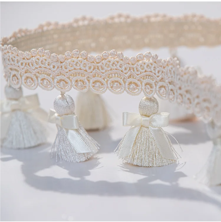 Close-up of Elysee tassel fringe trim in ivory and cream tones