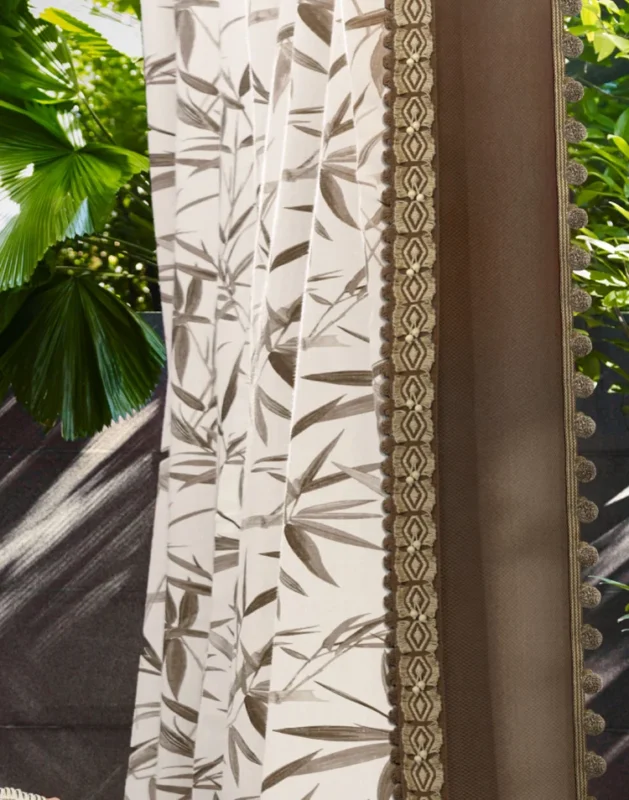 Ink bamboo print curtain with decorative tassel trim in outdoor setting