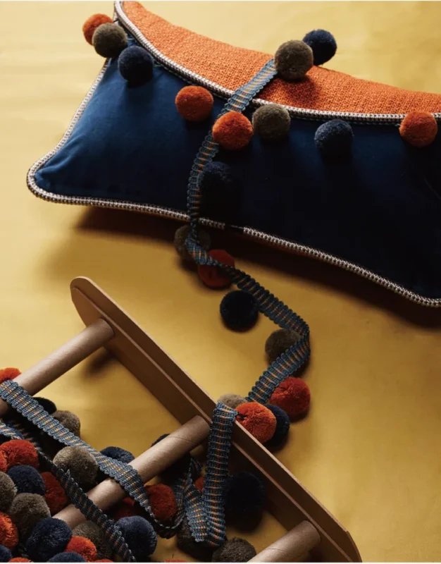 Cloud Dream Pom Pom Trim on Navy and Orange Cushions