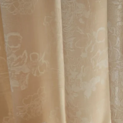 Soft jacquard curtain panel with floral texture beside window and vase