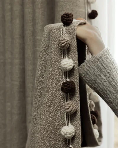 Chenille curtains in cocoa jacquard with tassel trim detail beside a tea cup