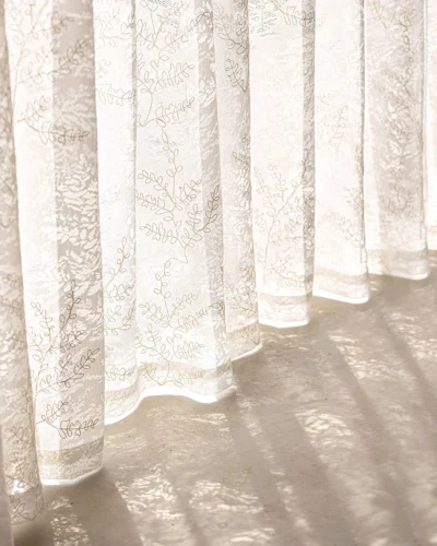 Close-up of the rope-embroidered floral sheer curtain hem in ivory—light-filtering lace with airy, elegant drape.