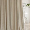 Basketweave texture curtain pooling softly on the floor beside a window, soft woven drapes in a modern living room.