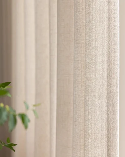 Close-up of textured curtain fabric with soft vertical folds, lattice texture curtain beside blurred leaves.