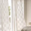 Block Stripe Sheer Curtain – soft beige check voile hanging in a bright bedroom window.