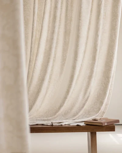 Blossom Whisper sheer curtain in beige floral jacquard, softly draped behind a simple wooden bench