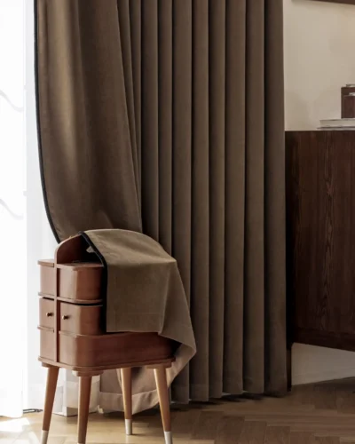 Mocha blackout curtain behind a wooden side table and chair in a cosy corner