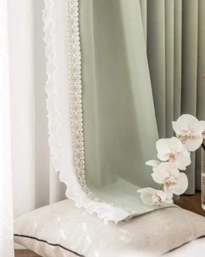 Sage green lace curtain panels in a bright bedroom, floor-length with soft pleats