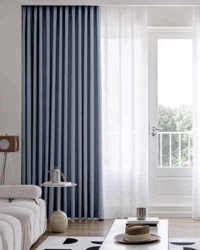 Steel blue curtains in a modern living room with sheer white drapes