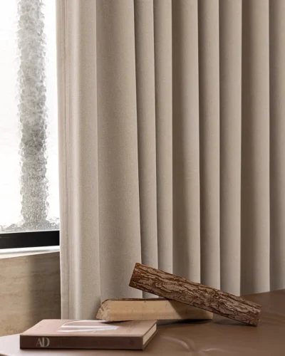 Beige blackout curtains in a modern room with sheer white drapes