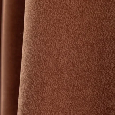 Cinnamon herringbone blackout curtain fabric – warm brown textured upholstery-like weave close-up