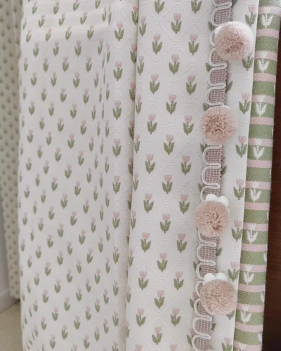 Embroidered sheer curtain close-up with petite floral repeat and pom pom trim edge