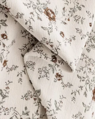 Ivory floral jacquard curtain fabric close-up in Cocoa Bloom, neutral vintage floral texture