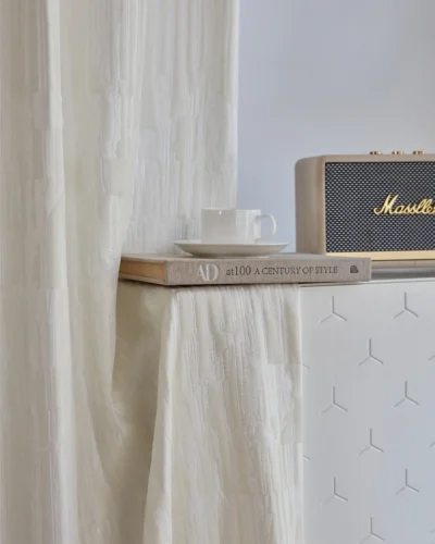 Cloudwash Jacquard Curtain hanging beside a table, subtle relief texture with light filtering
