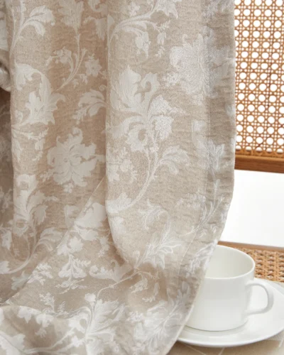 Close-up of warm beige floral jacquard sheer curtain with vine pattern, light filtering by the window