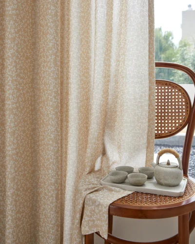 Ditsy floral jacquard sheer curtain in warm beige, light filtering with soft privacy beside a rattan chair
