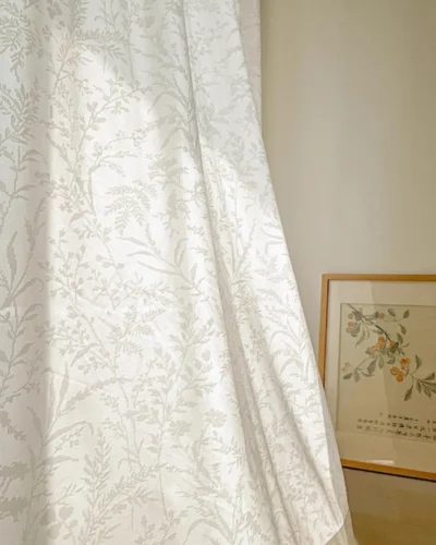 Ivory Botanica Jacquard Curtain hanging in a bright room with subtle floral vine texture