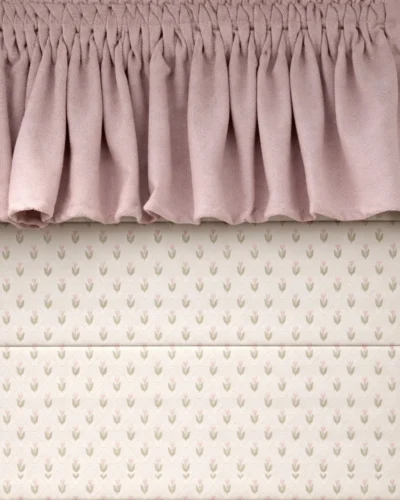 Close-up Roman shade with tiny tulip jacquard pattern in off-white, topped with a dusty pink ruffle valance.