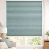 Fine texture semi-blackout honeycomb blind in soft blue-green shown in a bright modern living room window