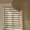 Semi-blackout waterproof Floating Vane Shangri-La Blind in a soft neutral room