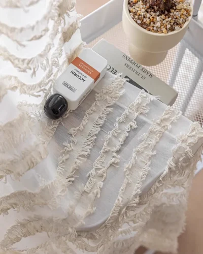 Hand touching the Frosted Feather Sheer Curtain to show its airy texture and soft feather-inspired detail