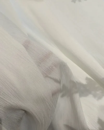 soft white linen texture sheer curtain draped over a bright bedroom window with natural light