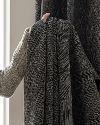 Charcoal Herringbone Blackout Curtain fabric showing dark grey textured herringbone pattern and soft drape.