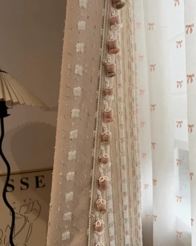 Cotton Candy Cloud Blackout Curtain with soft pink textured fabric, decorative tassel trim and sheer curtain layering.